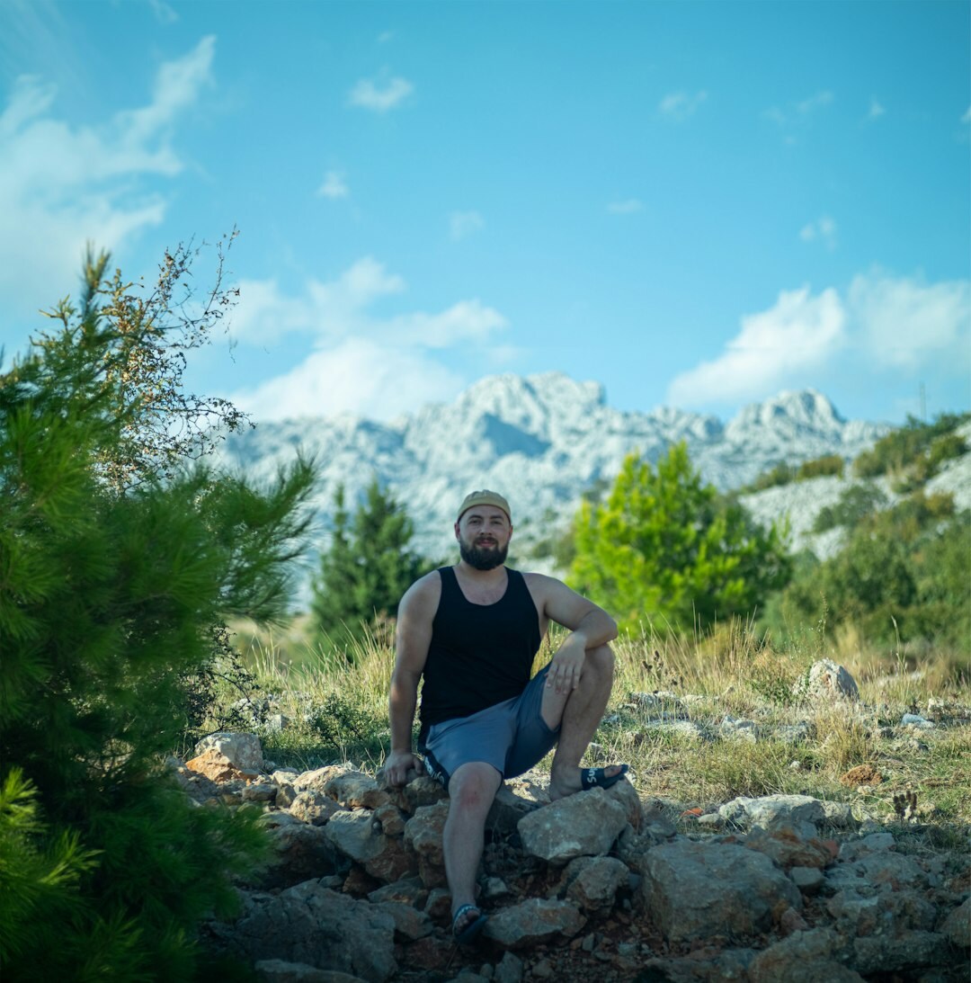 Croatian shepherd standing with his flock in the mountains